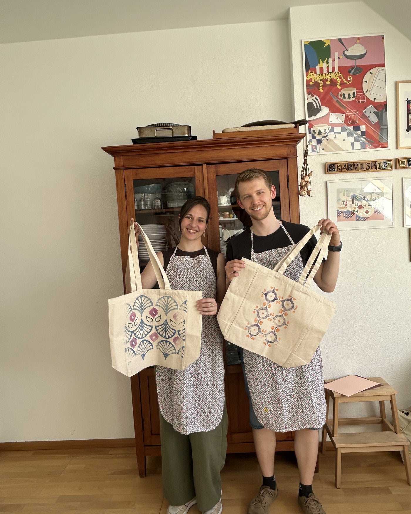 Two guests proudly holding their finished totes