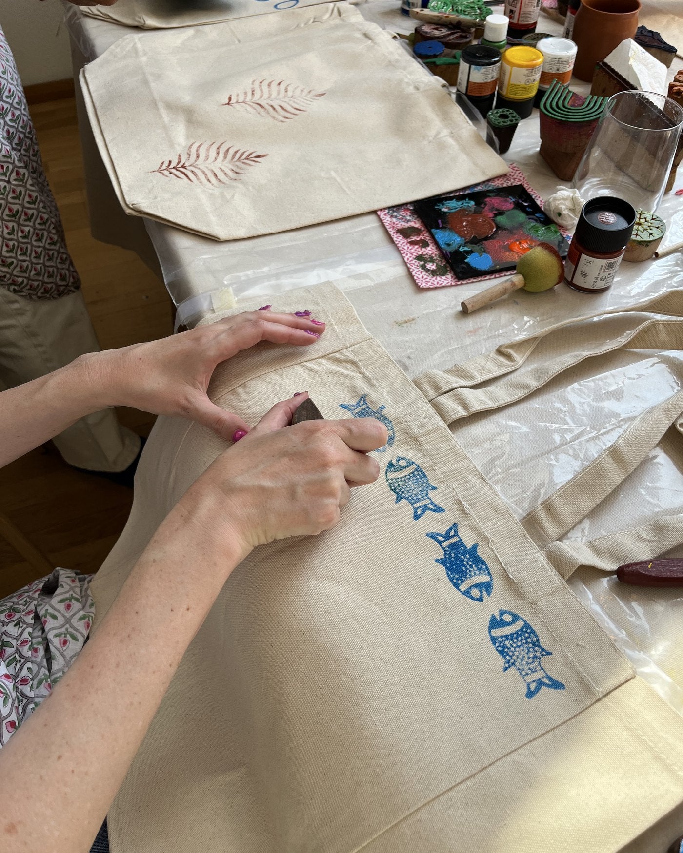 Stamping blue motifs onto a tote together