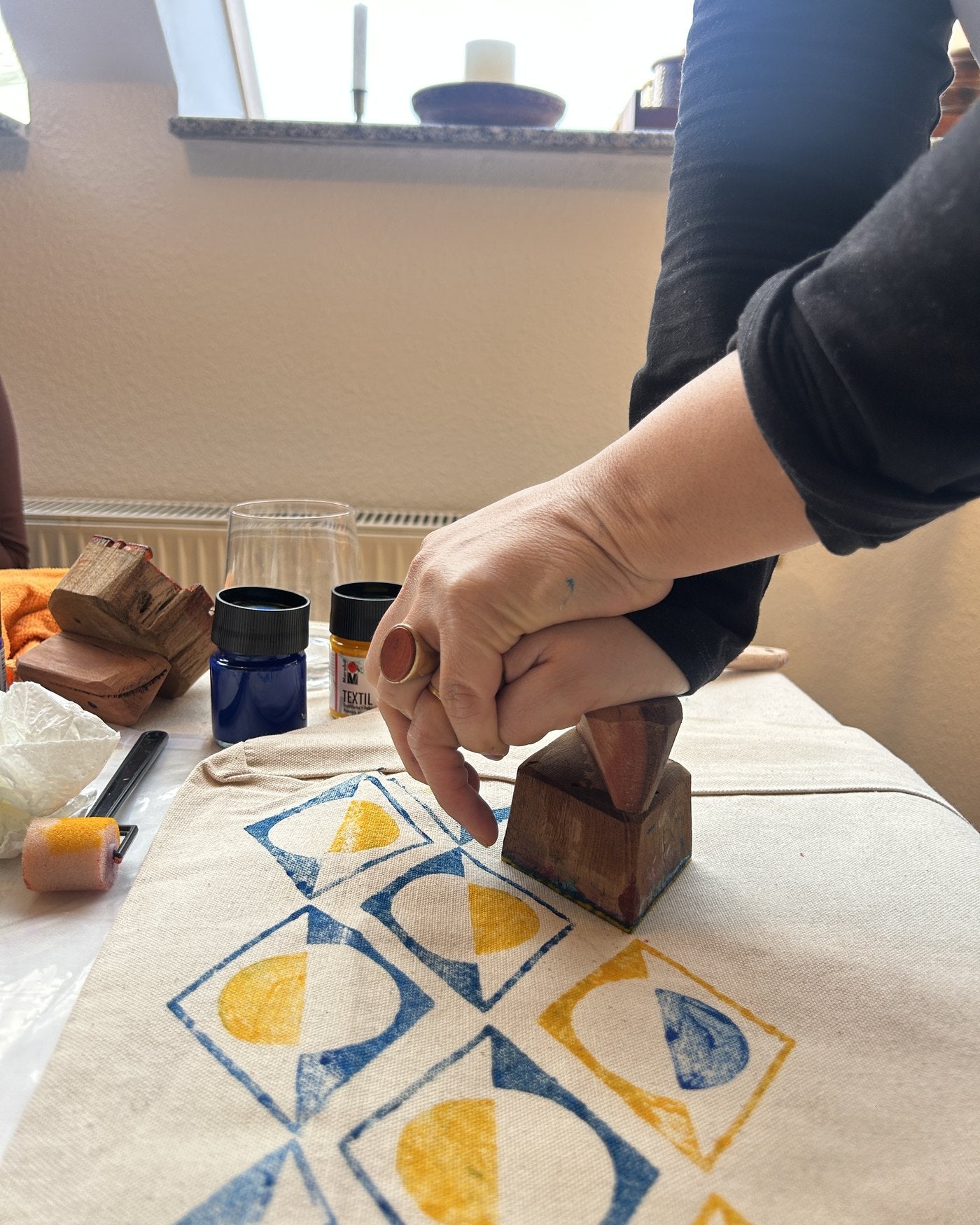 Pressing a hand-carved block onto the fabric