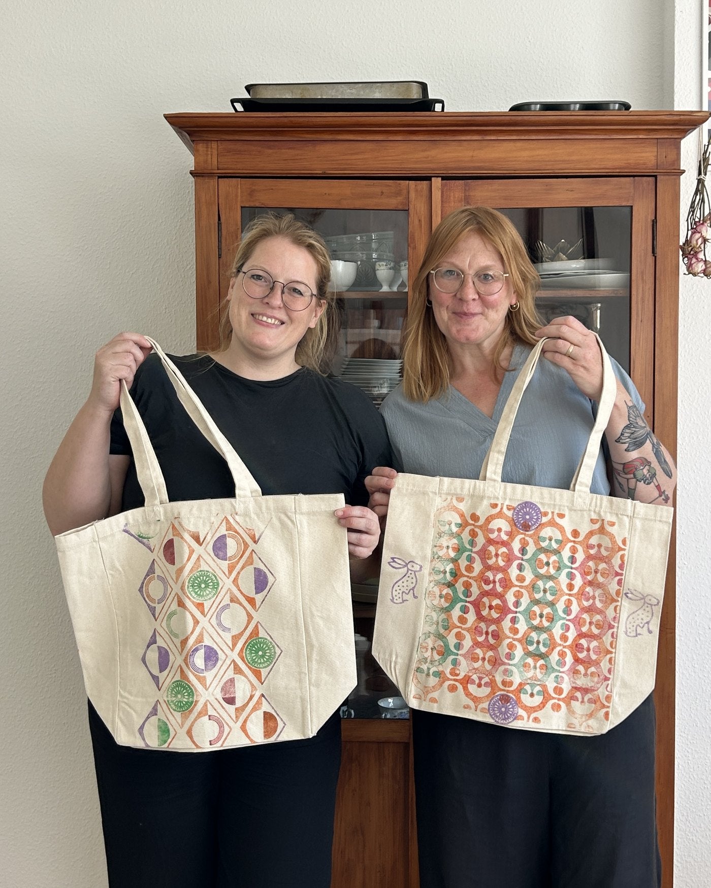 Two guests with their printed totes