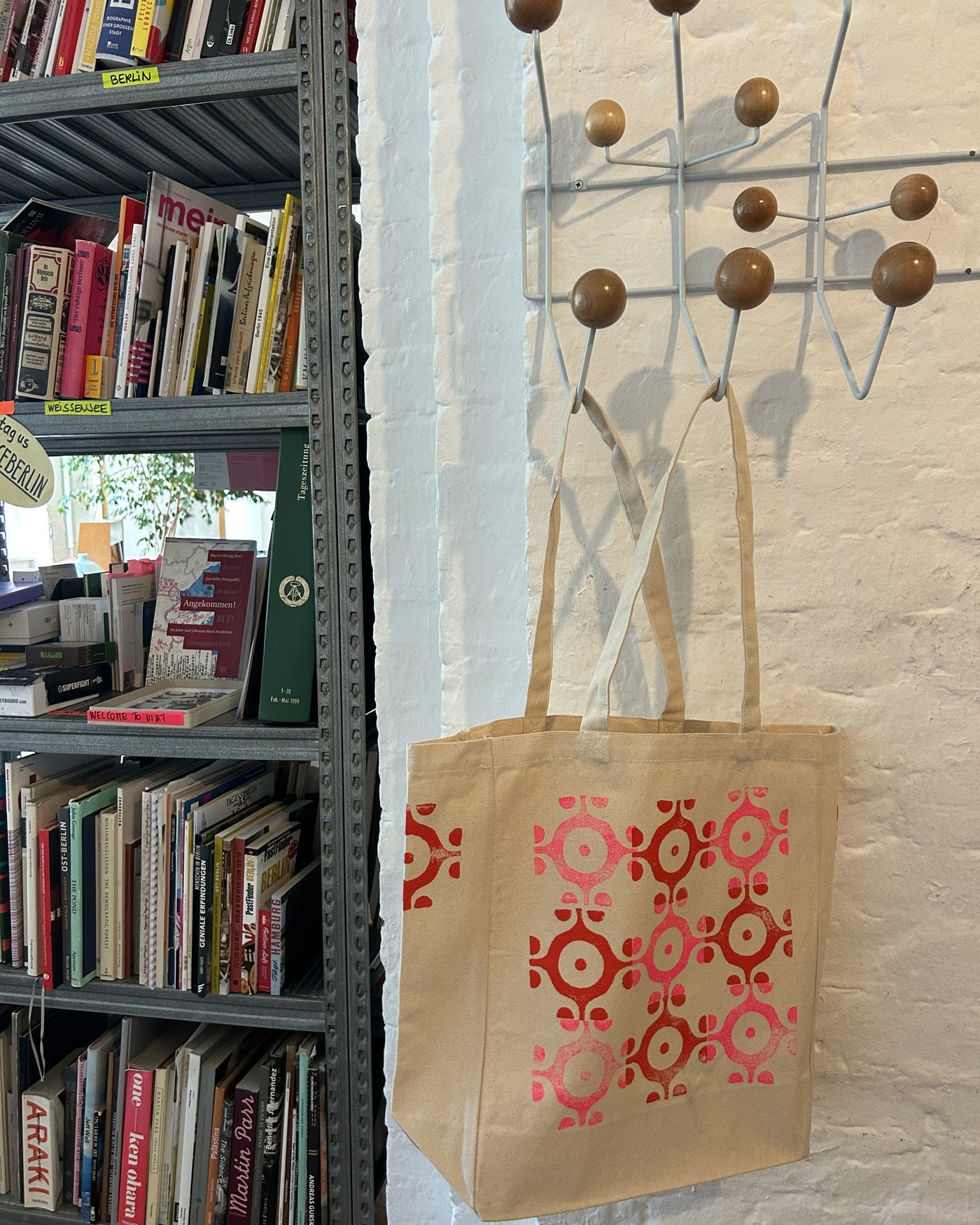 A printed tote hanging on the studio coat rack