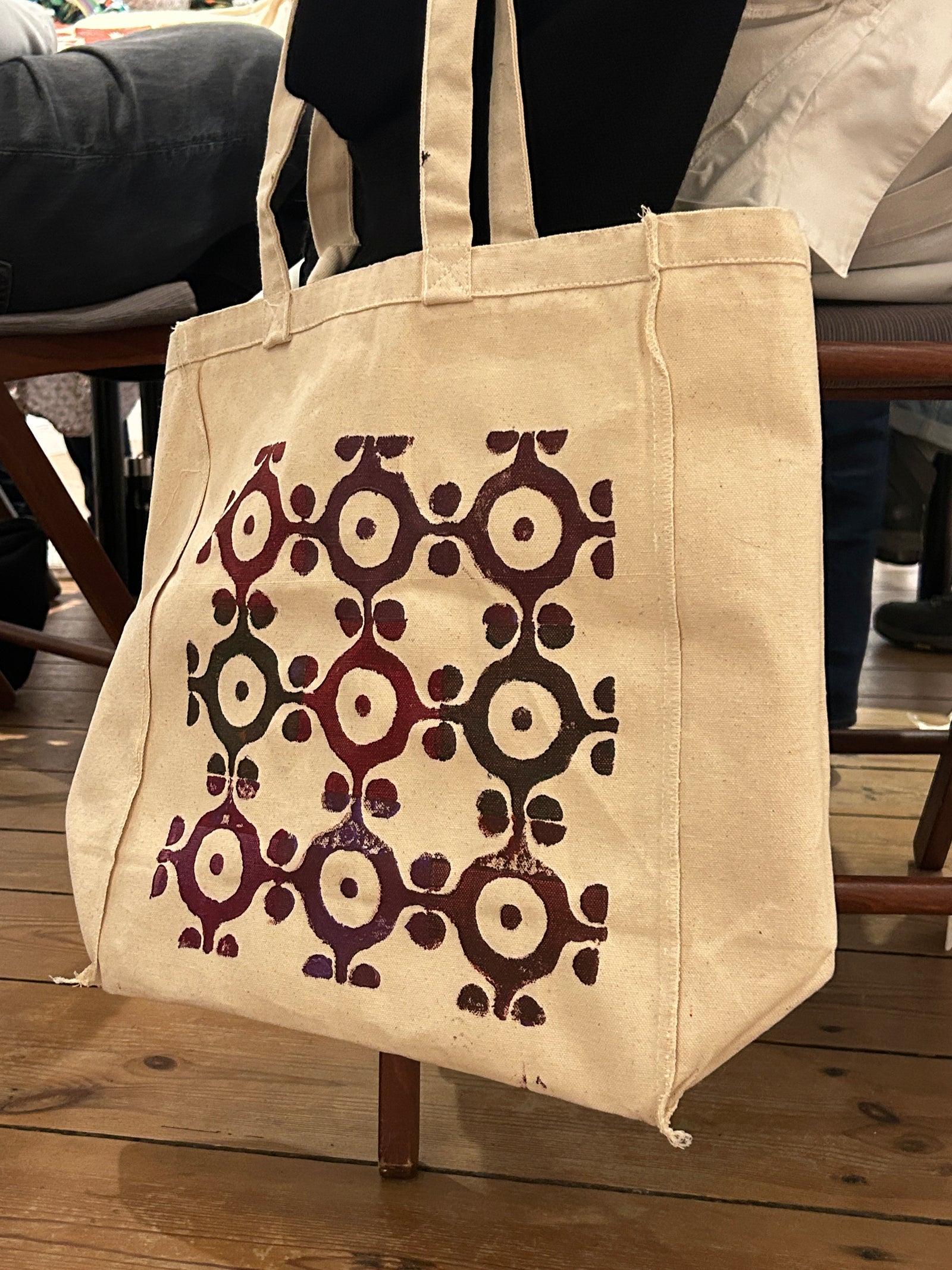 A printed tote drying on a chair