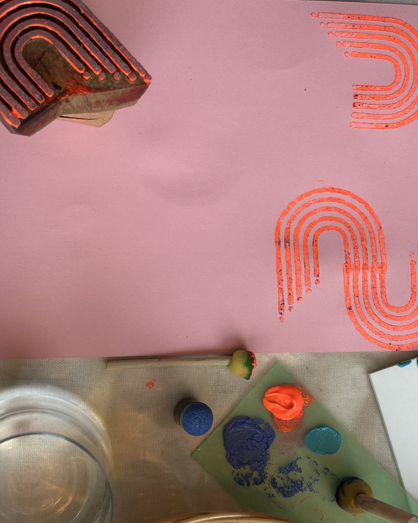 Orange waves stamped on pink paper