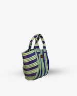 Striped handbag with purple and green pattern on a white background