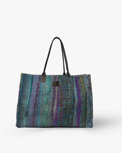 Multicolored blue striped tote bag on a white background