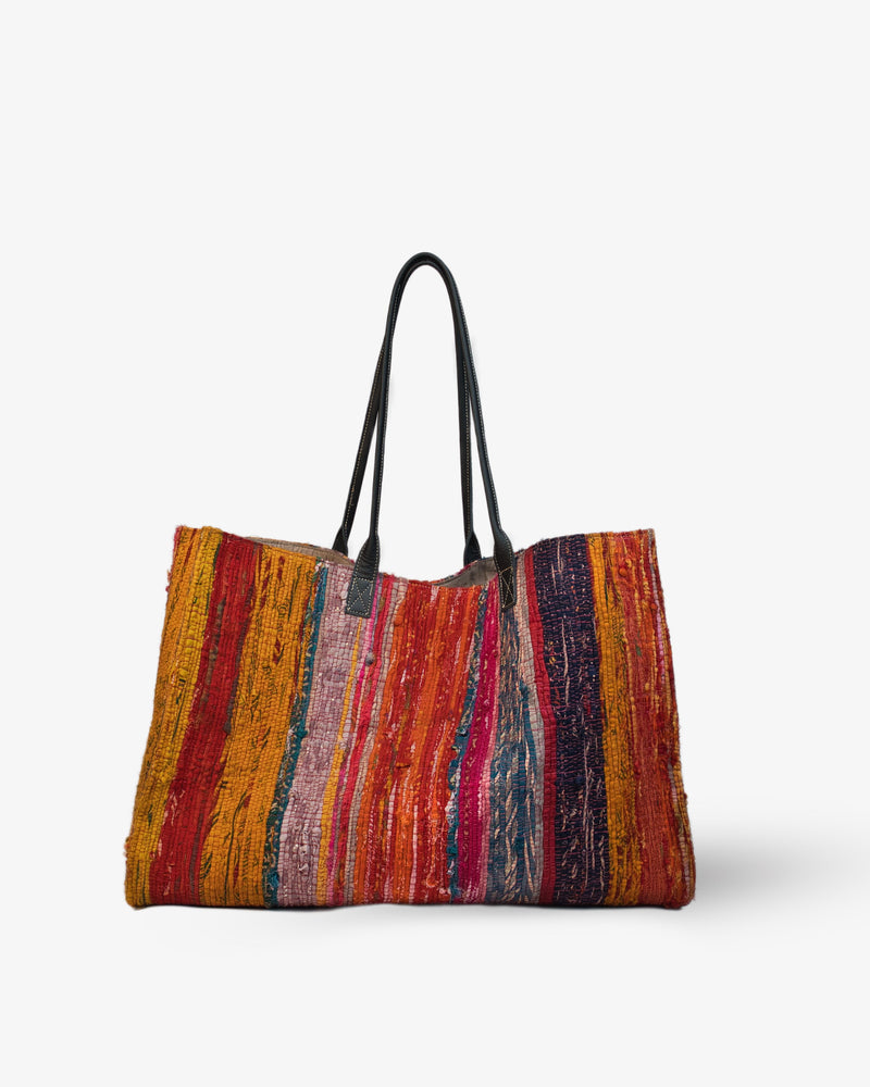 Colorful striped tote bag with black handles on a white background